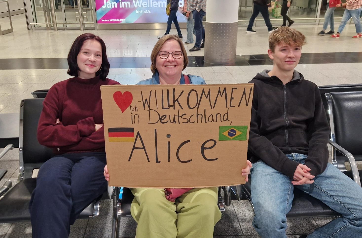 Recepção de Alice na Alemanha, com o cartaz Willkommen in Deutschland